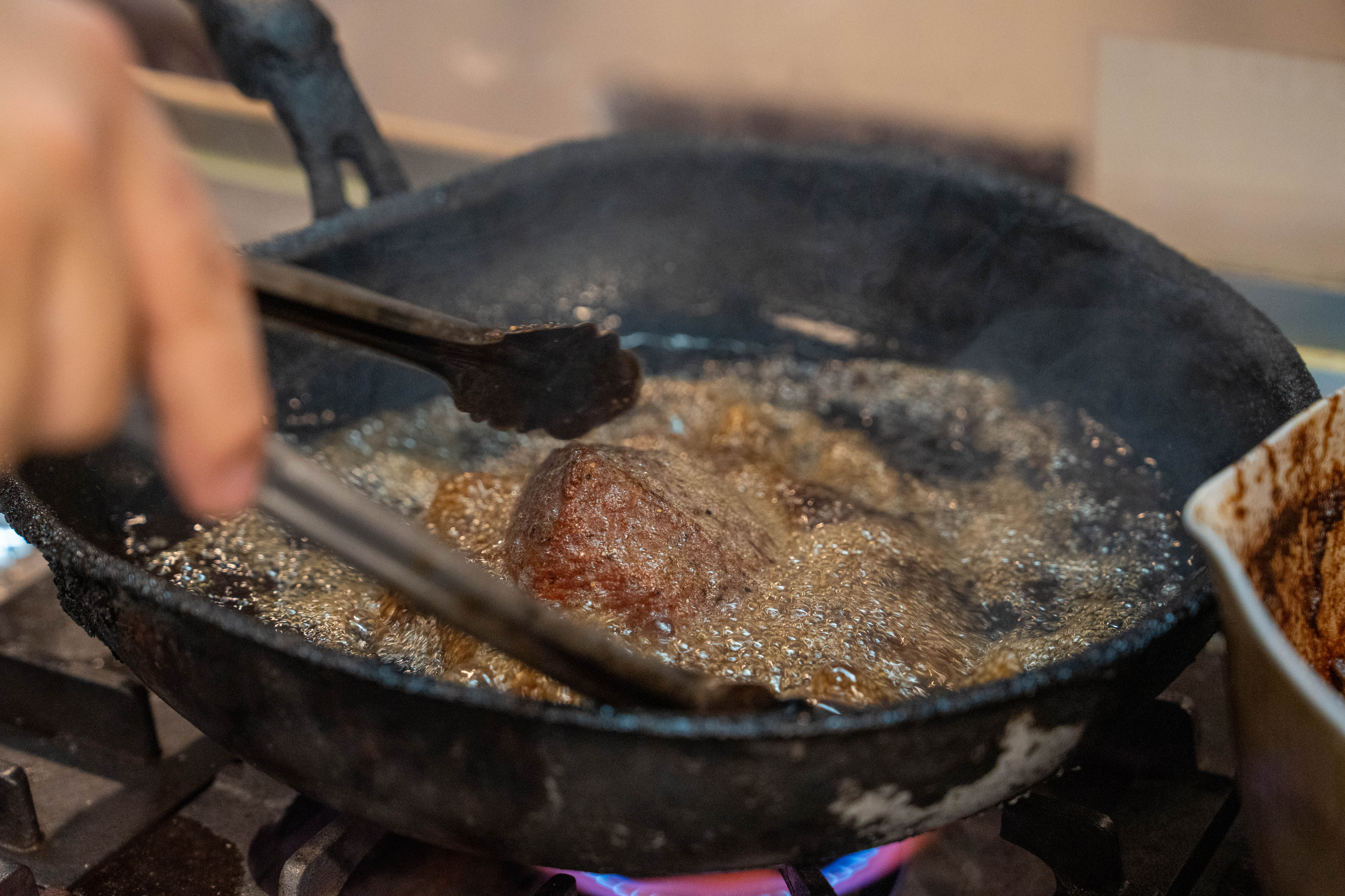 源兵衛 鉄鍋でお肉を揚げ焼きする様子